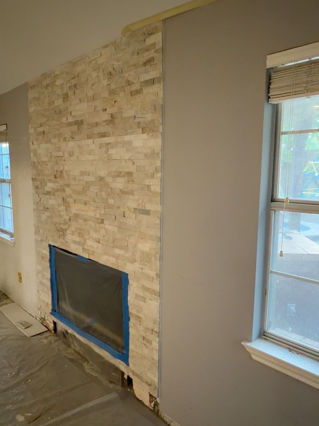 Angled view documenting the existing shallow stone face and firebox surround