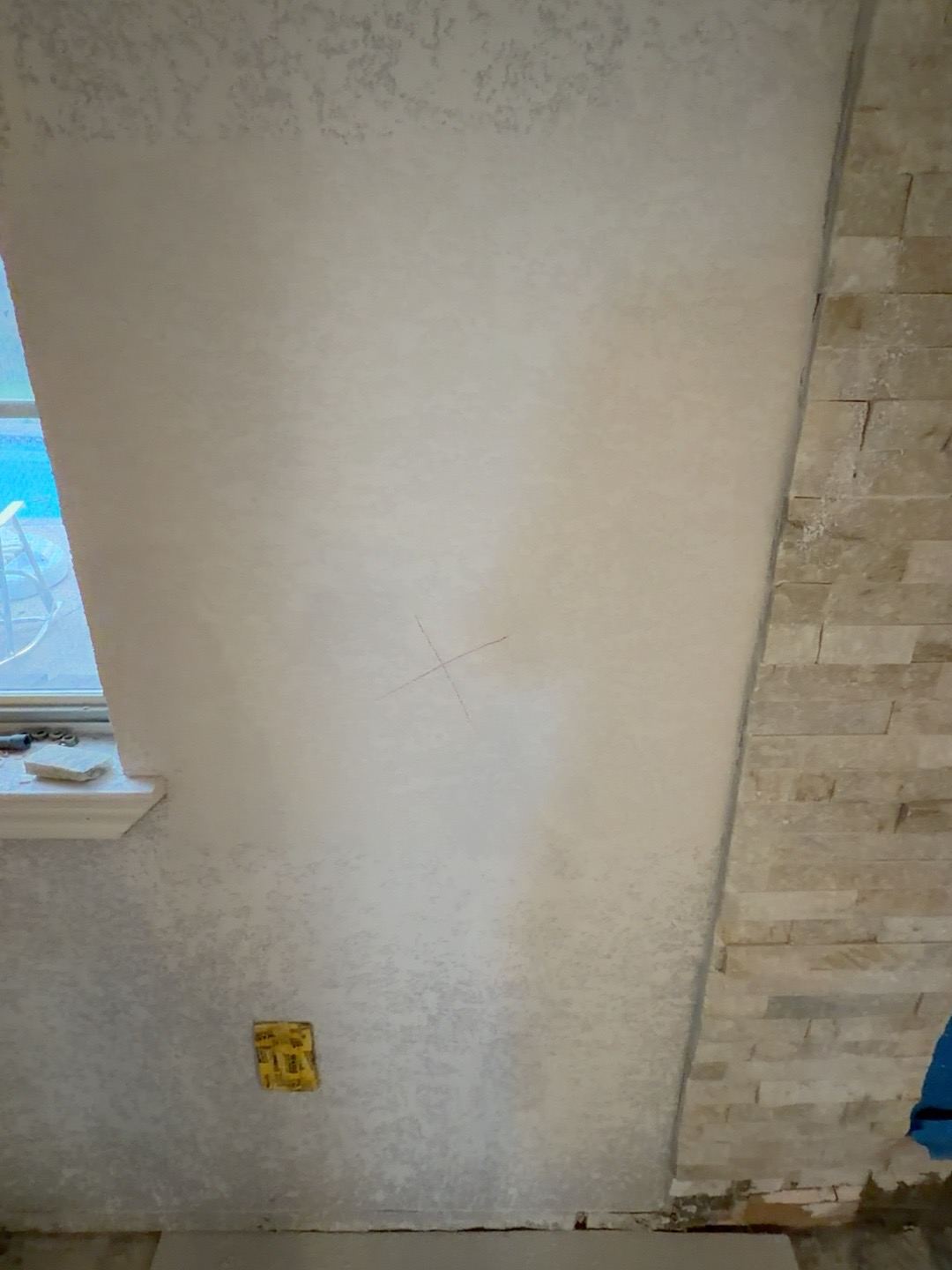 Fireplace wall with a red X marking the approximate gas shutoff opening